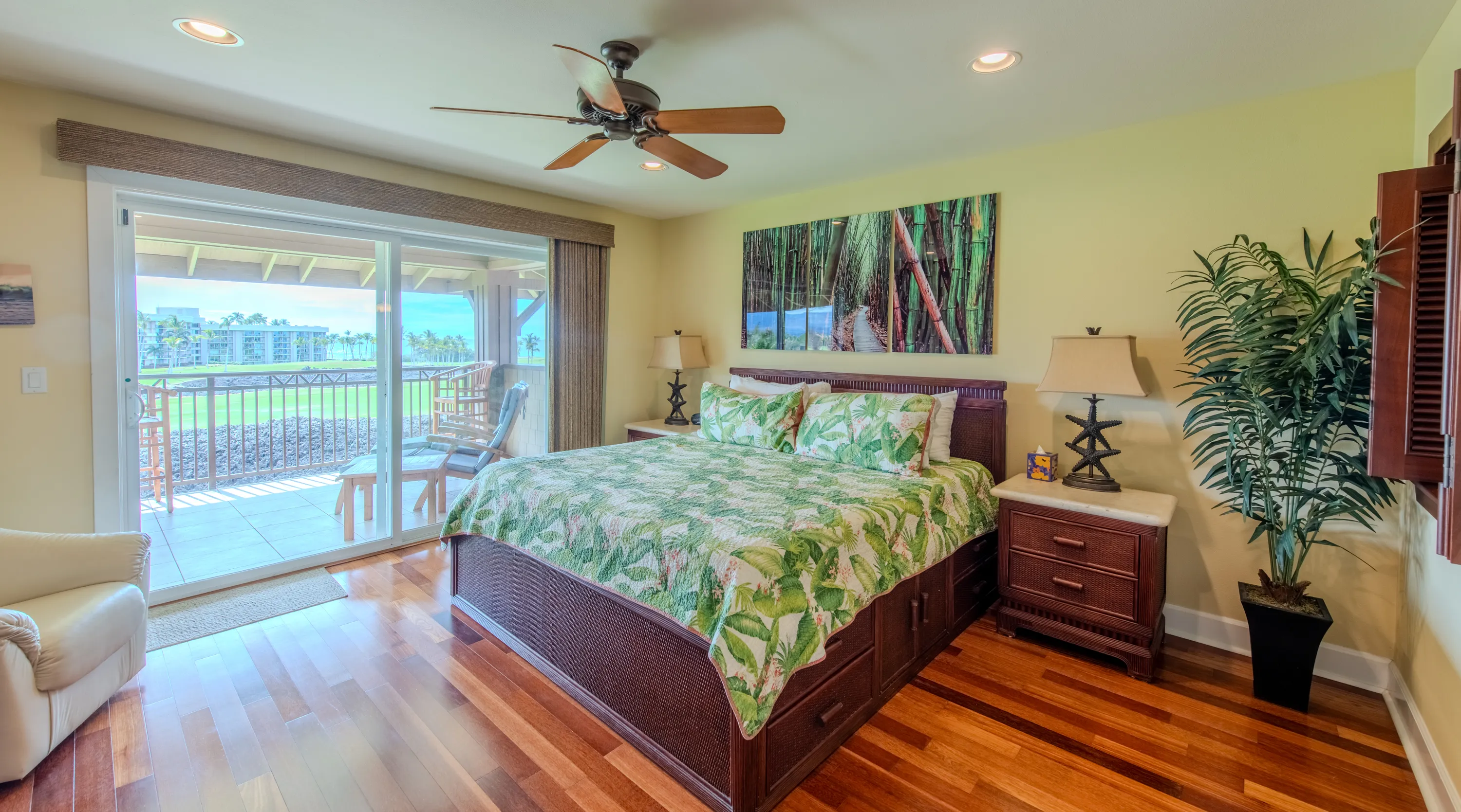 Primary bedroom with a king bed opening to a lanai over the golf course