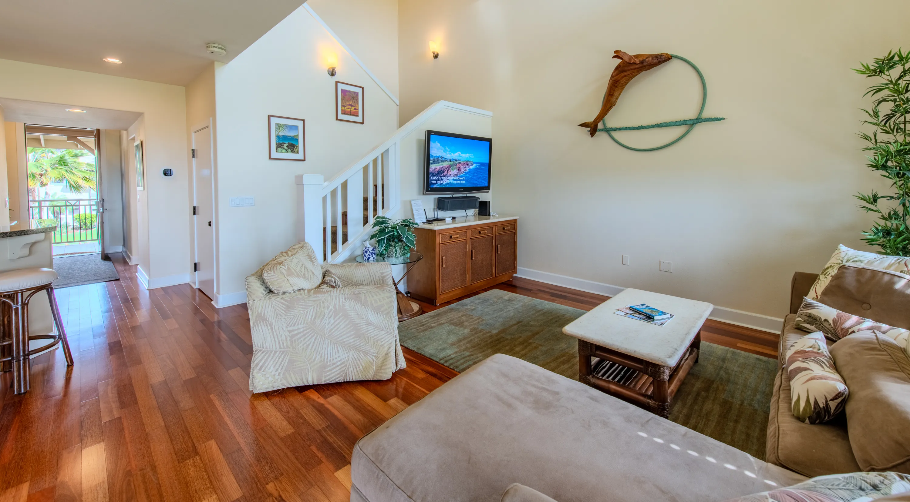 Open living room with a sofa, lounge seating, and a flat-screen TV