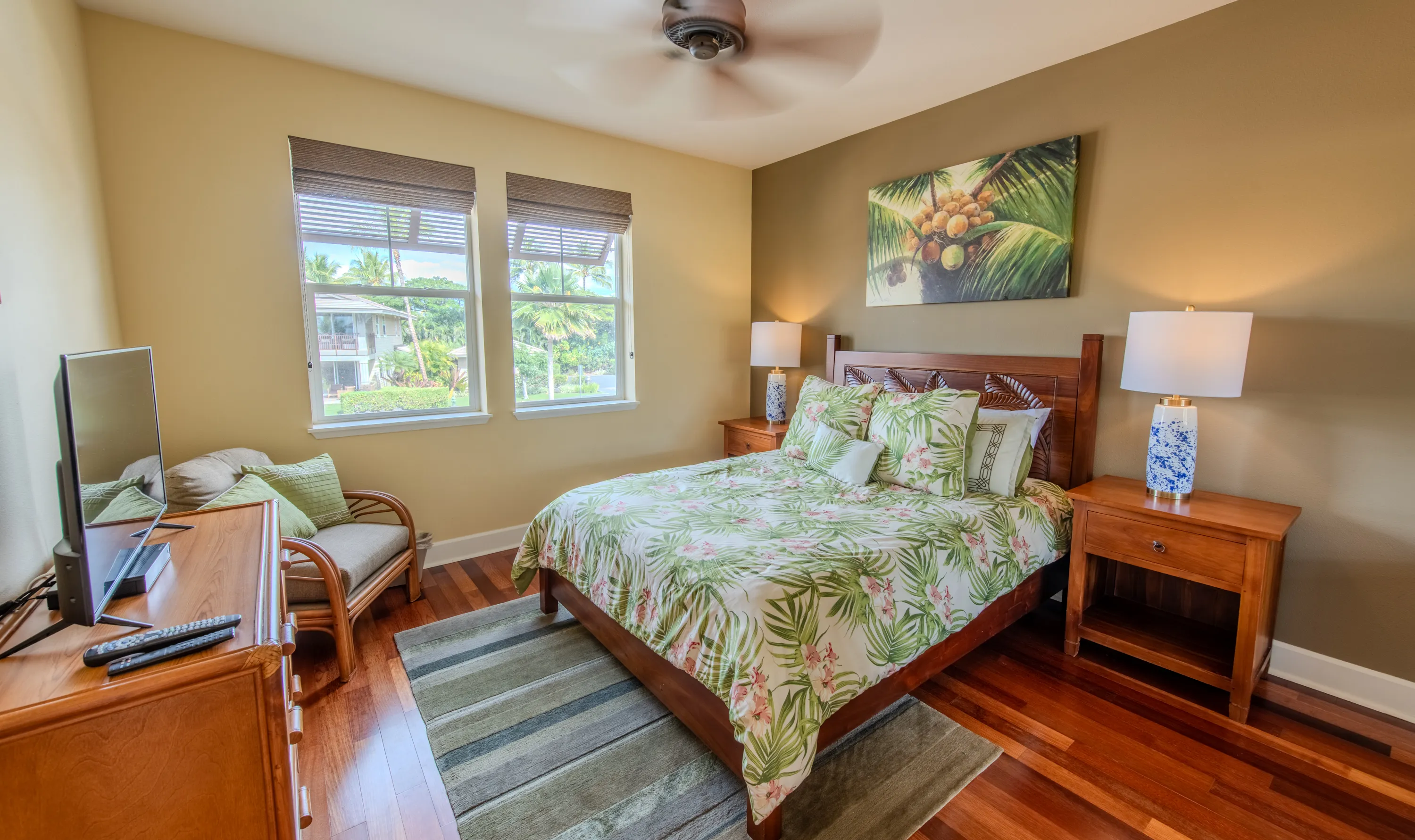 Queen bedroom with a garden outlook and coconut-palm artwork