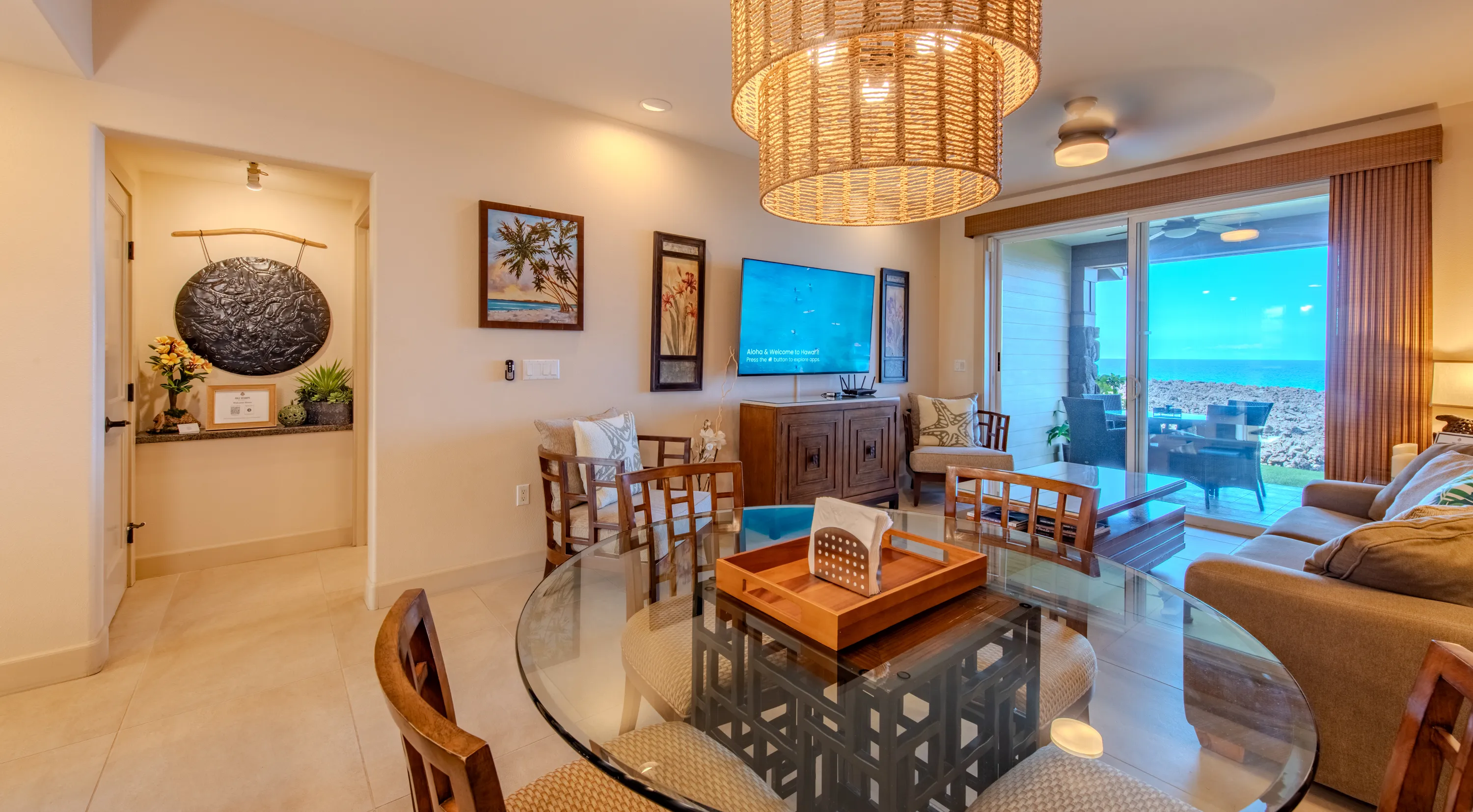 Glass dining table for four with the ocean beyond the lanai