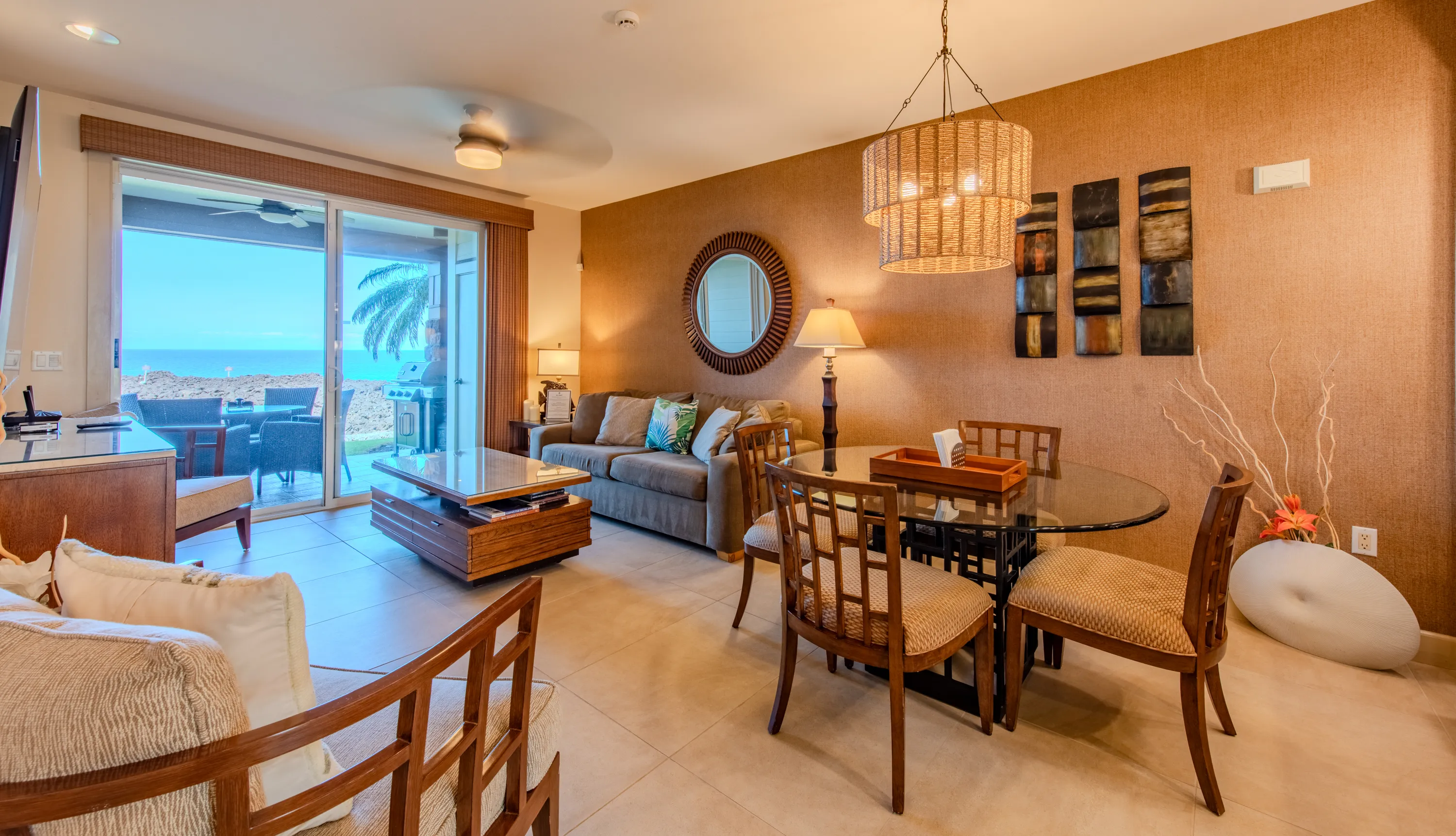 Living and dining area with the ocean framed beyond the lanai