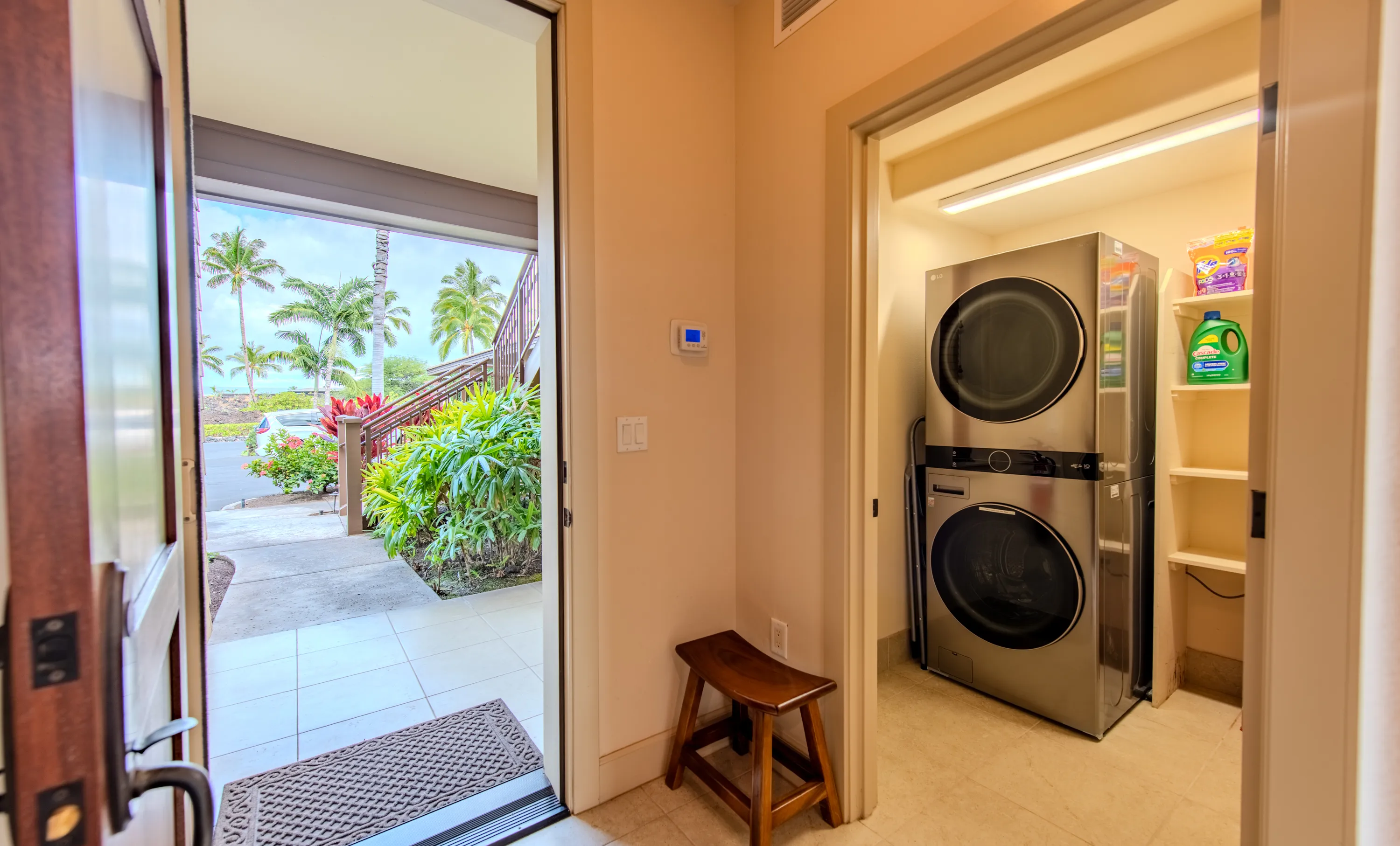 Entry with the front door open to the garden and a full-size stacked washer and dryer