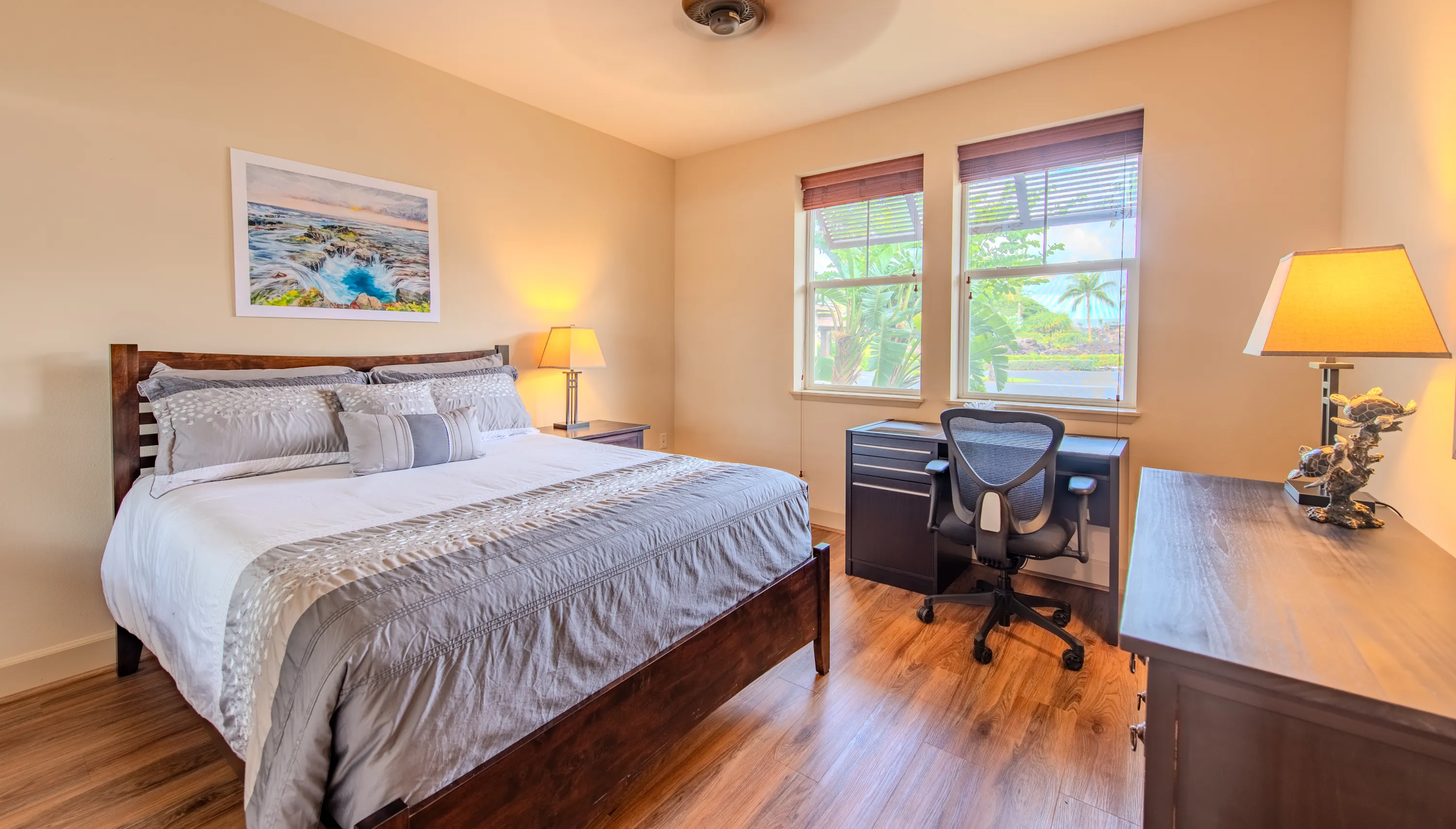 Second bedroom with a queen bed, a work desk, and a garden view