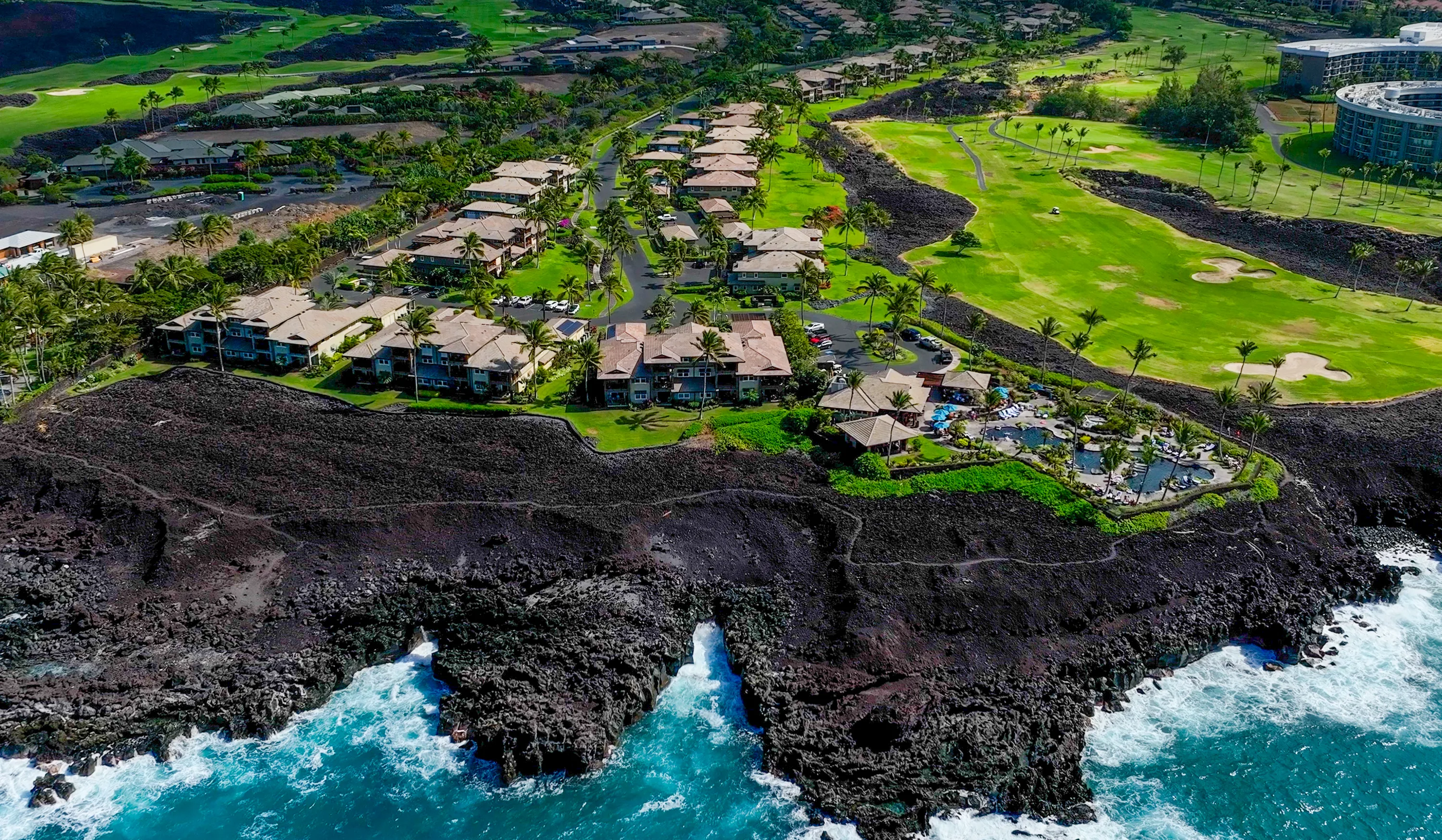 Aerial view of the Hali'i Kai community set between golf greens and the lava-rock Kohala Coast shoreline