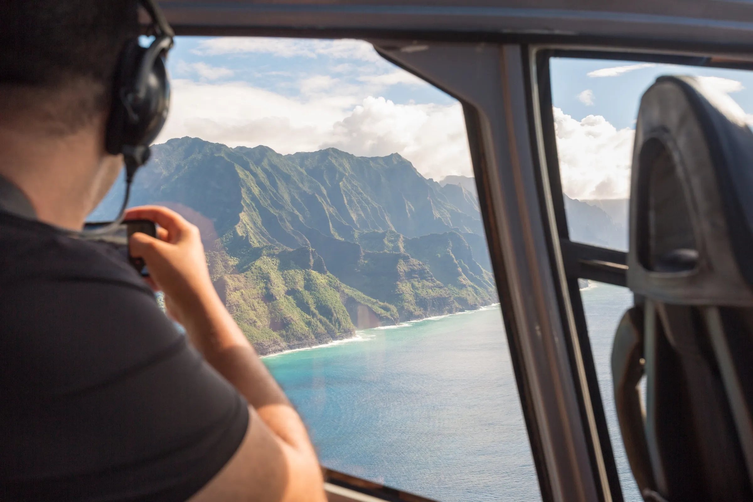 A tour helicopter flying over green Big Island valleys and waterfalls