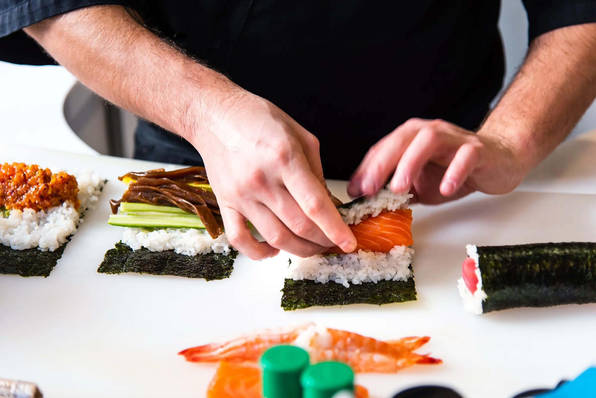 A sushi chef rolling fresh nigiri and maki by hand