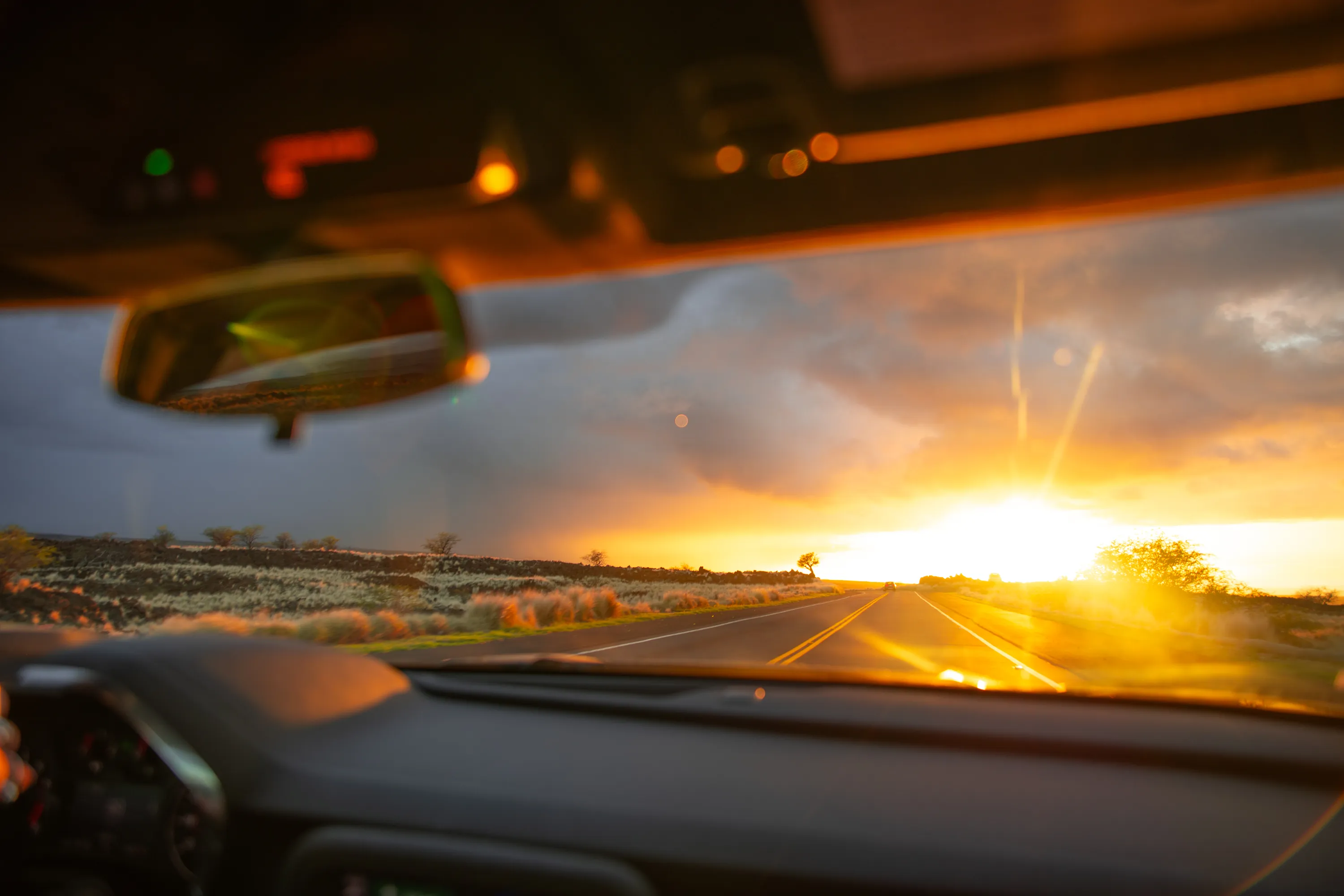 The long straight road toward Waikoloa at sunset, lava fields on either side